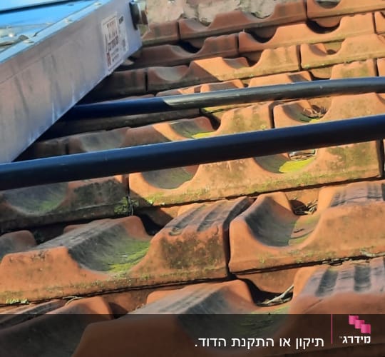 קולט שמש מותקן על גג רעפים עם צינורות מחוברים